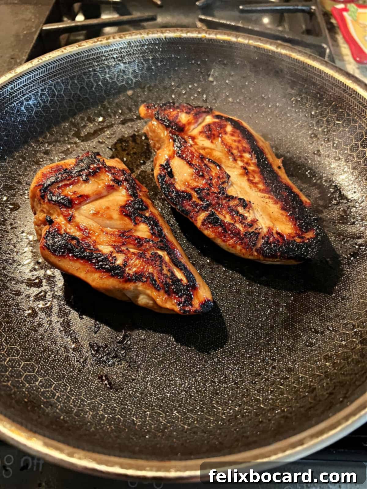 Cooked chicken breasts in a pan.