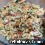 A close-up view of a sweet and creamy macaroni salad, showcasing its rich texture and inviting appearance.