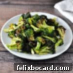 Perfectly air-fried broccoli florets arranged on a clean white plate, ready to be served as a healthy and crispy side dish.