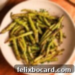 A serving of air-fried sesame garlic green beans, beautifully arranged to highlight their vibrant color and crispy texture.