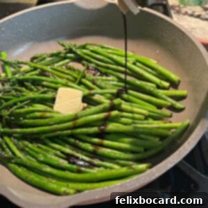 Freshly sautéed asparagus spears glistening as they are drizzled with rich balsamic vinegar, showcasing a vibrant and flavorful side dish.