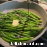 Freshly sautéed asparagus spears glistening as they are drizzled with rich balsamic vinegar, showcasing a vibrant and flavorful side dish.