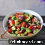 A vibrant balsamic cucumber tomato salad presented in an elegant serving bowl, showcasing the fresh, colorful ingredients.