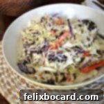 Creamy keto coleslaw served in a white bowl with a spoon, ready to be enjoyed as a healthy side dish.