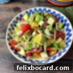 A vibrant serving bowl filled with fresh Mexican Avocado Salad, highlighting the creamy avocado and crisp vegetables.