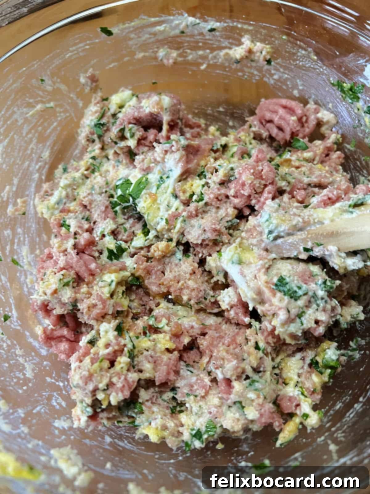 Combining ground chicken, ricotta, eggs, parmesan, panko, garlic, parsley, salt, and pepper in a large mixing bowl.