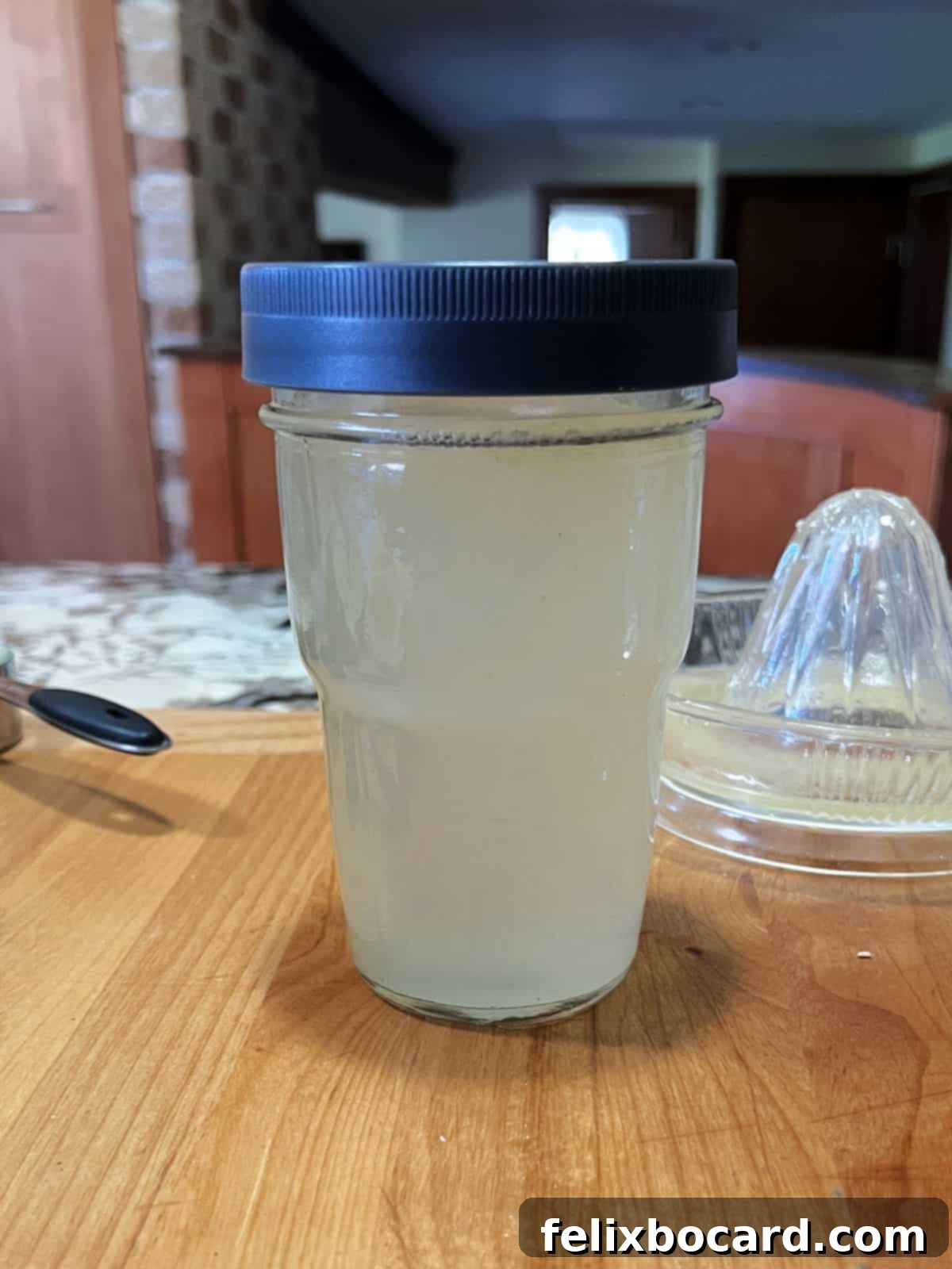 Homemade sweet and sour mix stored in a covered jar in the refrigerator.
