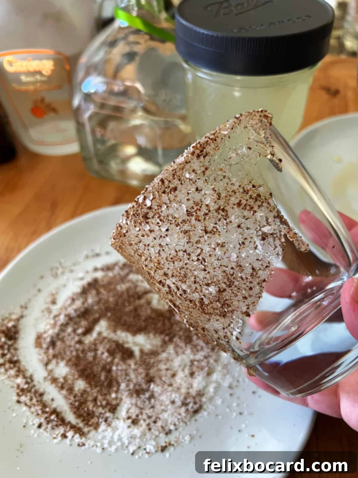 A margarita glass expertly coated with a mixture of salt and chili-lime seasoning, ready for the cocktail.