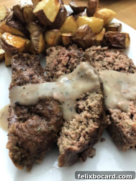 Ultimate Comfort Meatloaf 5 Slice of meatloaf with gravy and mashed potatoes