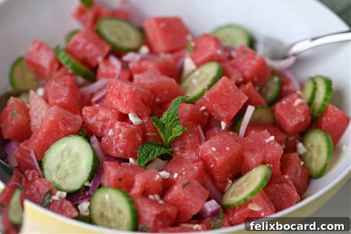Close up of watermelon feta salad with honey lime dressing, garnished with fresh mint.