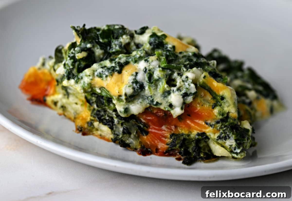 A serving of cheesy spinach casserole on a small plate, ready to be enjoyed.