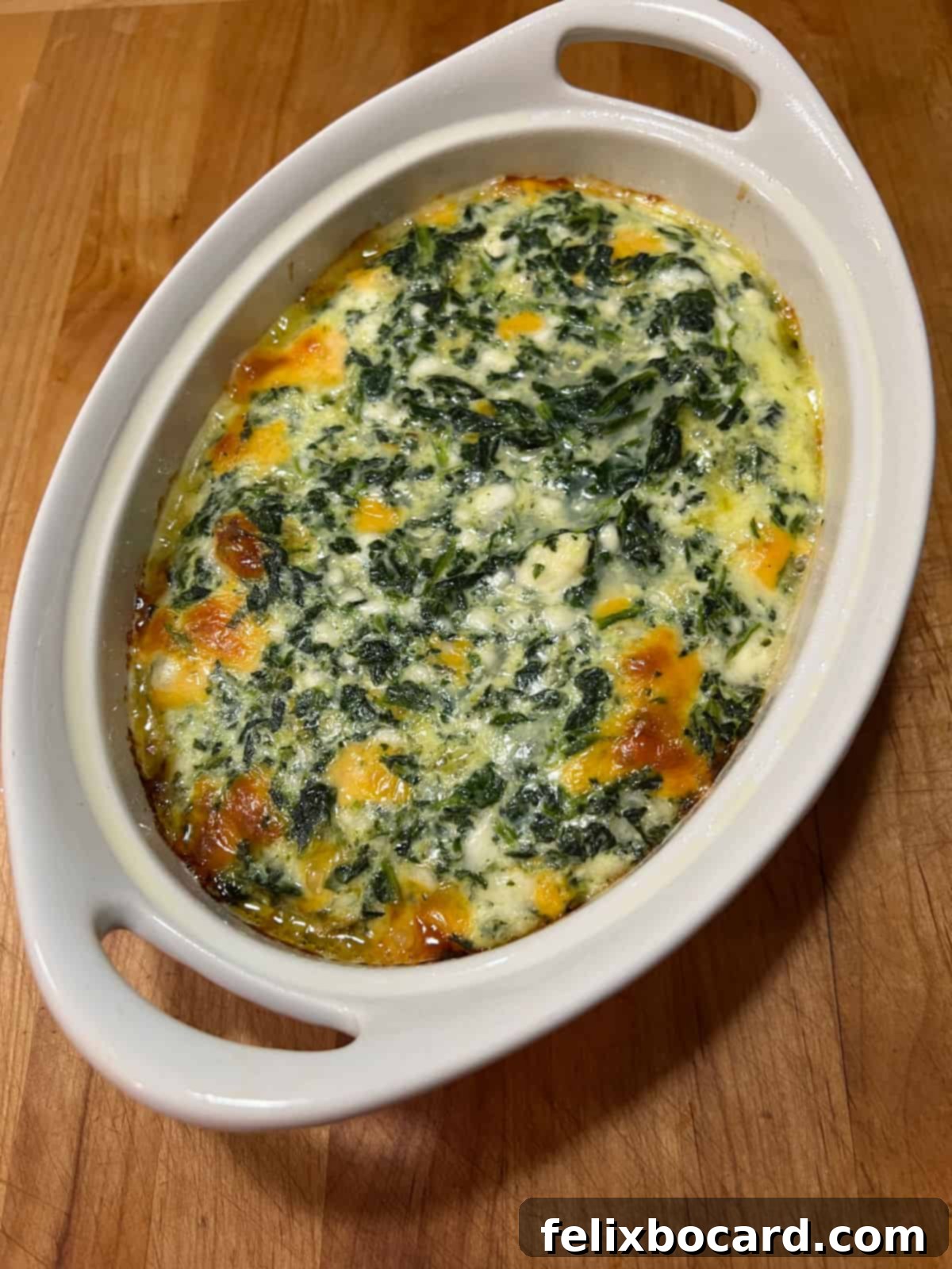 The freshly baked spinach casserole, golden and bubbly, right out of the oven.