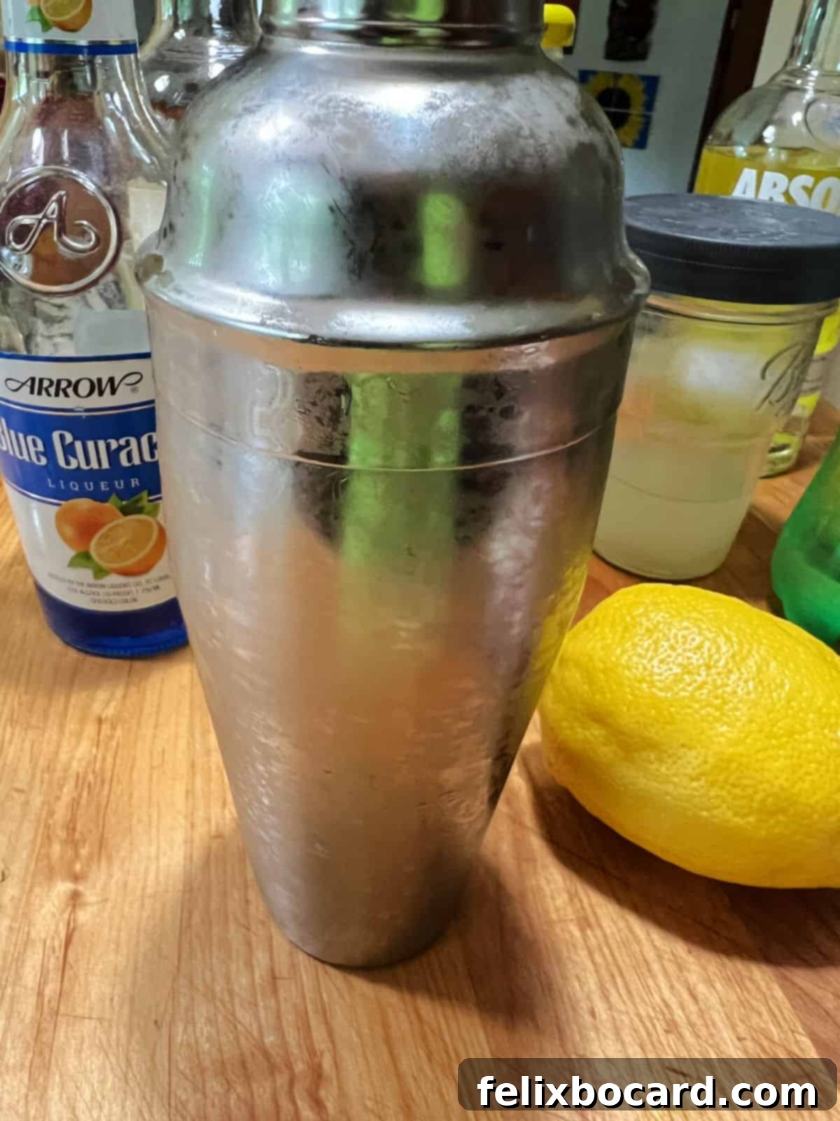 A cold, frosted cocktail shaker after vigorous shaking, ready to pour.