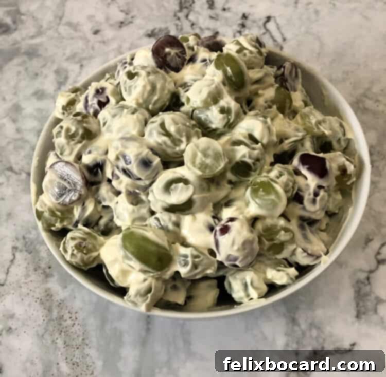 Grape salad in a white bowl with a spoon