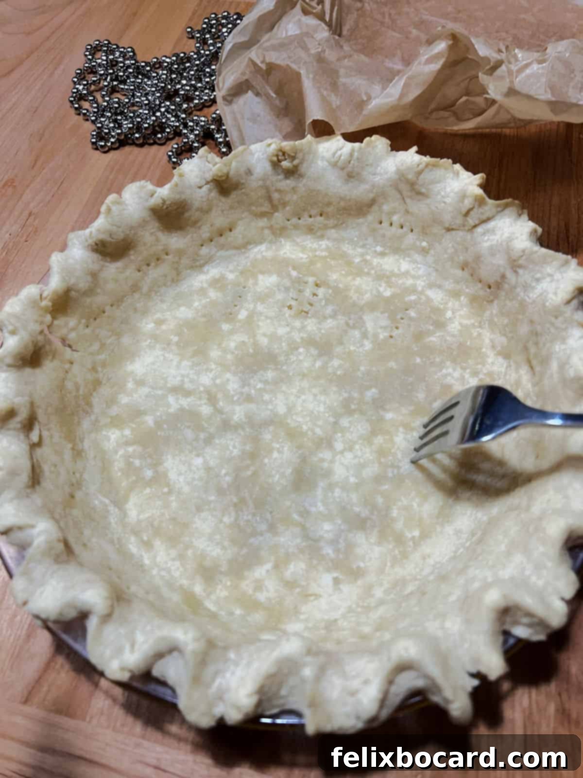 fork poking steam holes in pie crust.