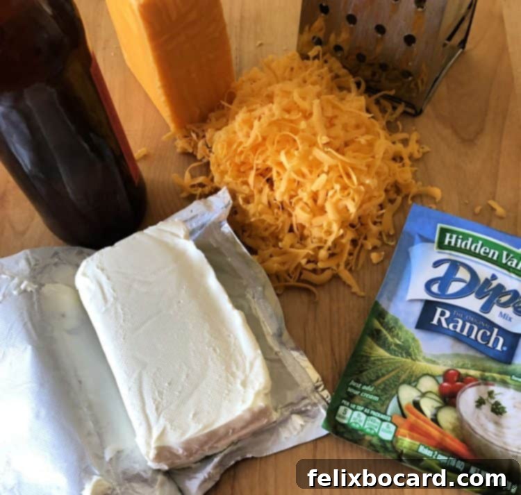 A collection of Beer Cheese Dip ingredients: cream cheese, beer, ranch dressing mix, and shredded cheddar cheese, ready for mixing.