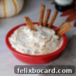 A square bowl of creamy beer cheese dip with pretzels, ideal for parties.