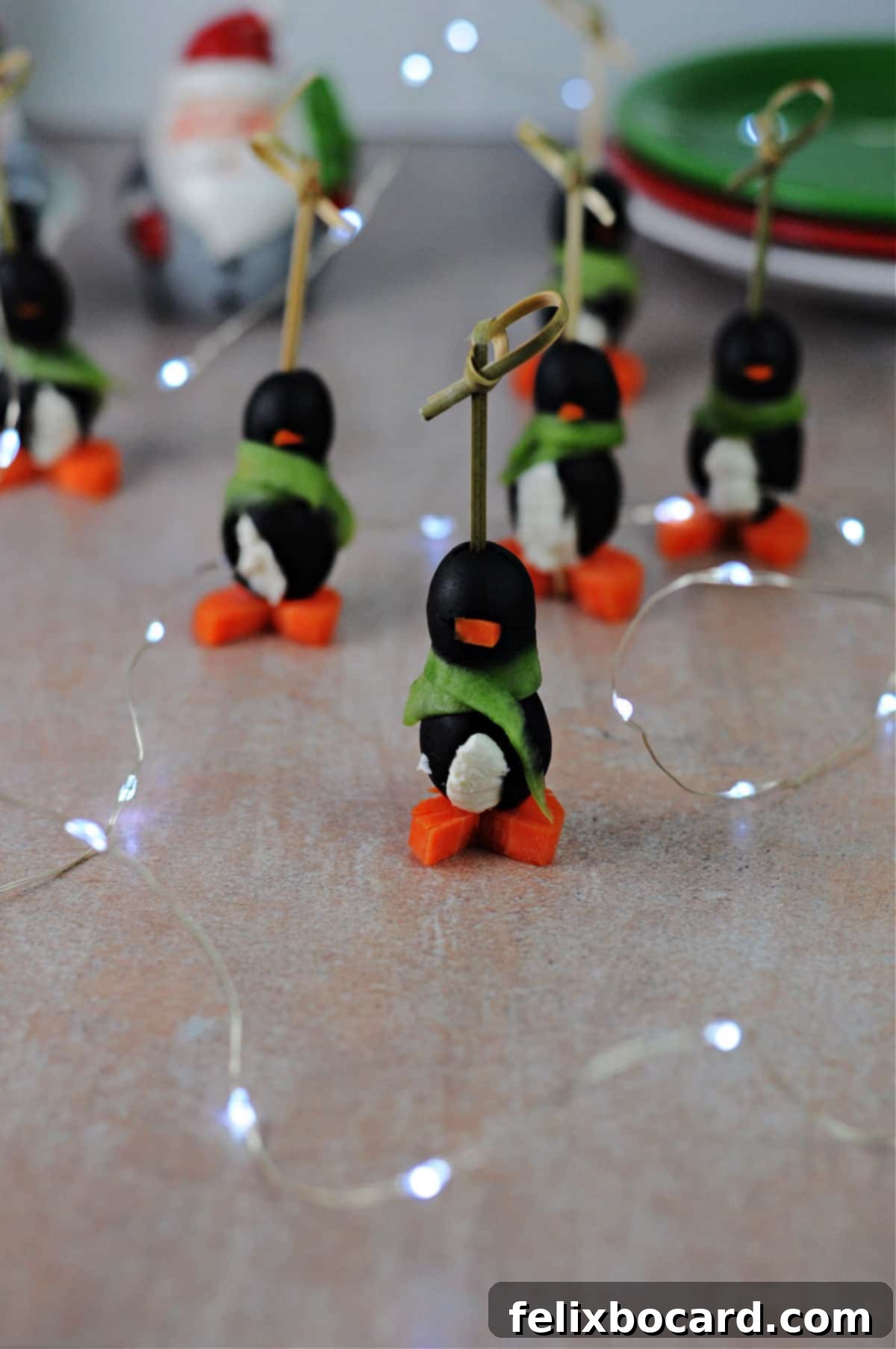 Penguin Party Bites 2 Adorable cream cheese penguin appetizers artfully arranged amidst twinkling fairy lights, ready for a festive holiday gathering.