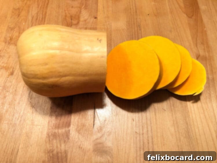Golden Butternut Squash Chowder 3 Butternut squash being cut into slices for easier peeling.
