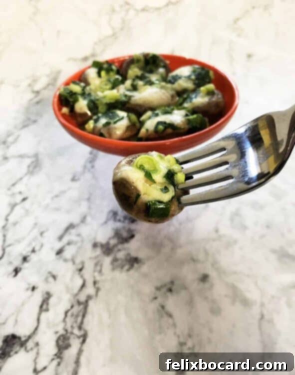 fork holding a brie stuffed mushroom
