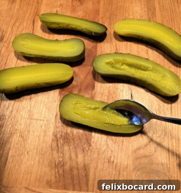 Scooping seeds from dill pickles to create tuna salad boats