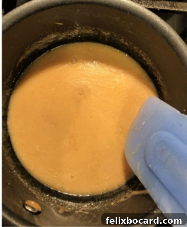 Caramel ingredients gently cooking in a pan, stirring to combine.