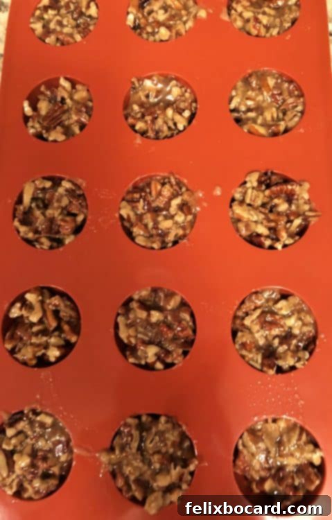 Perfectly shaped keto pecan clusters chilling in silicone molds.