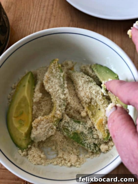 hand placing avocado slices in the bowl of meal