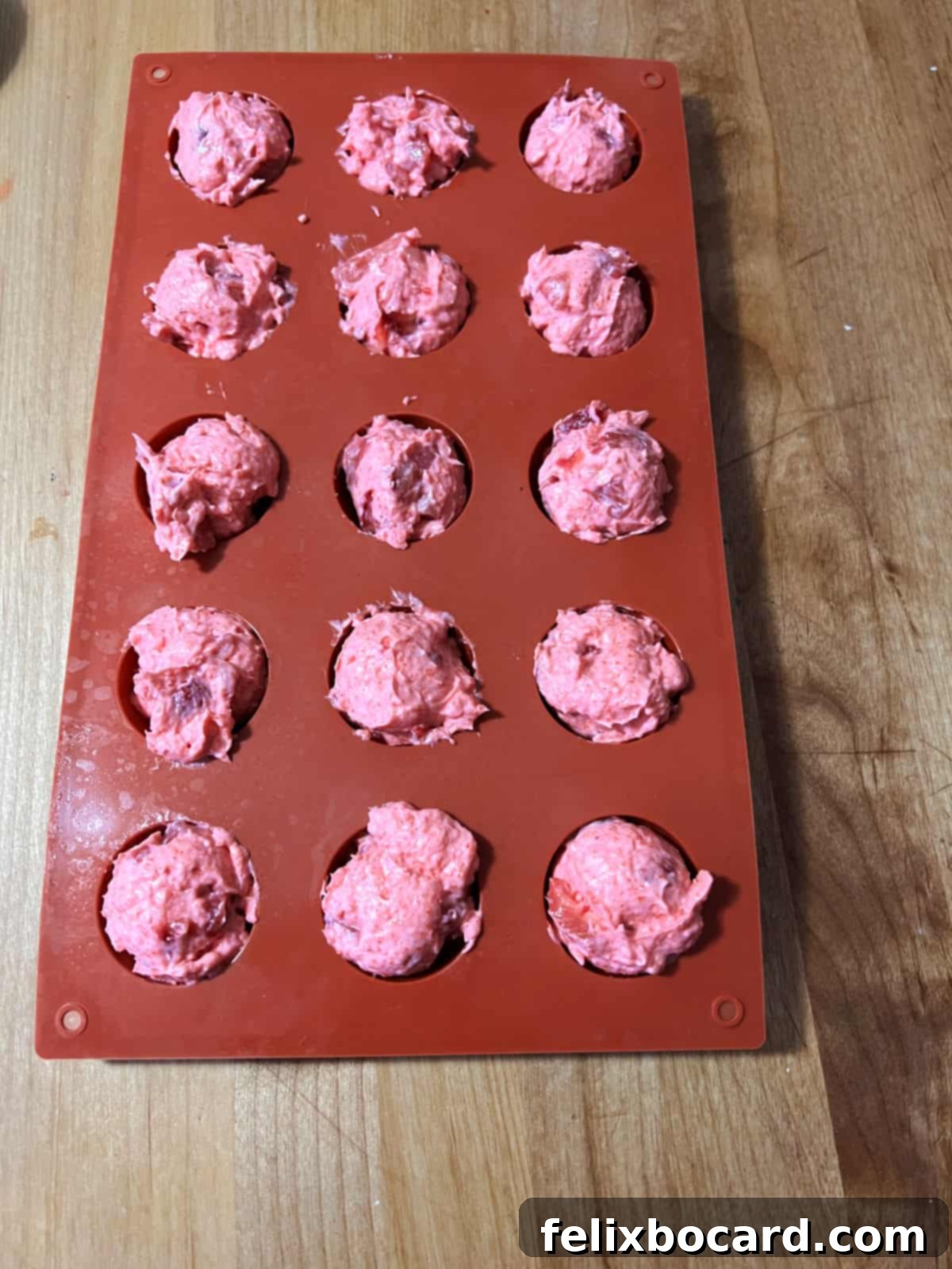 silicone mold filled with scoops of keto strawberry mix, ready to be frozen.