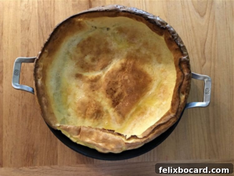 Baked Dutch Baby in skillet straight from oven, puffy and golden