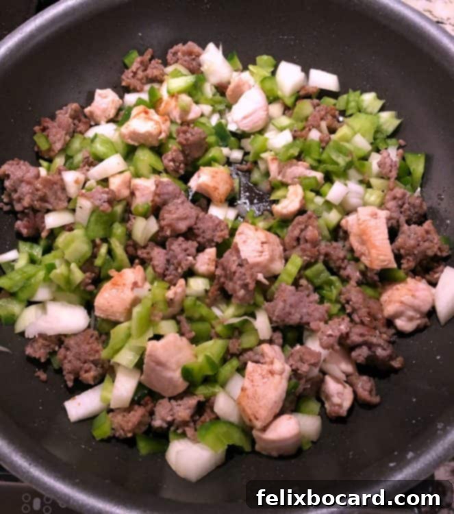 Weeknight Jambalaya 4 chicken, sausage, and vegetables browning in a large skillet.