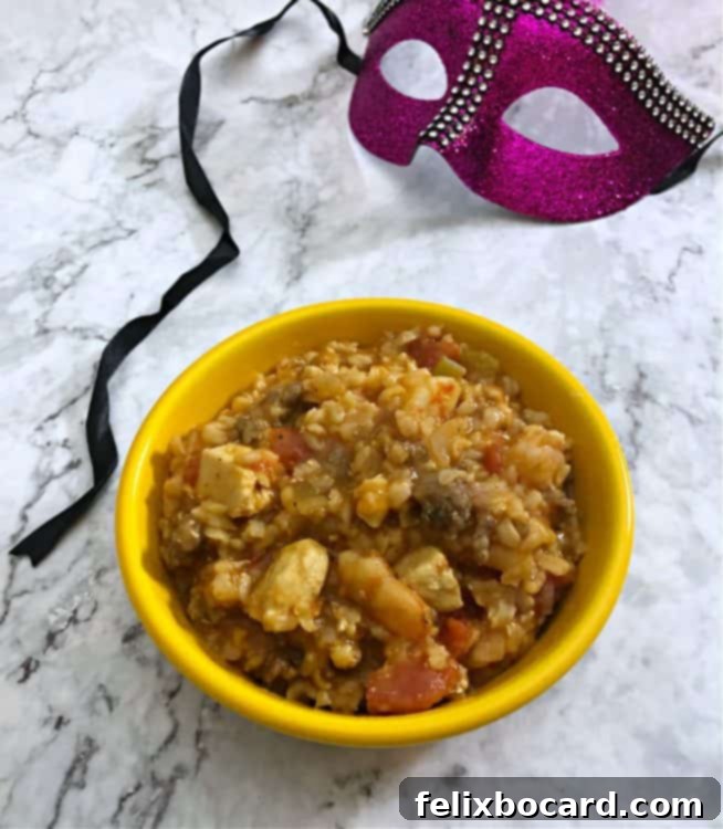 Weeknight Jambalaya 6 Jambalaya in a yellow bowl with a Mardi Gras mask nearby, suggesting a festive occasion.
