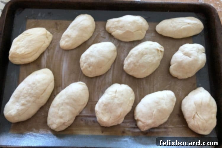 Deli Style Sandwich Rolls 3 Unbaked hoagie rolls arranged on a baking sheet before their second rise