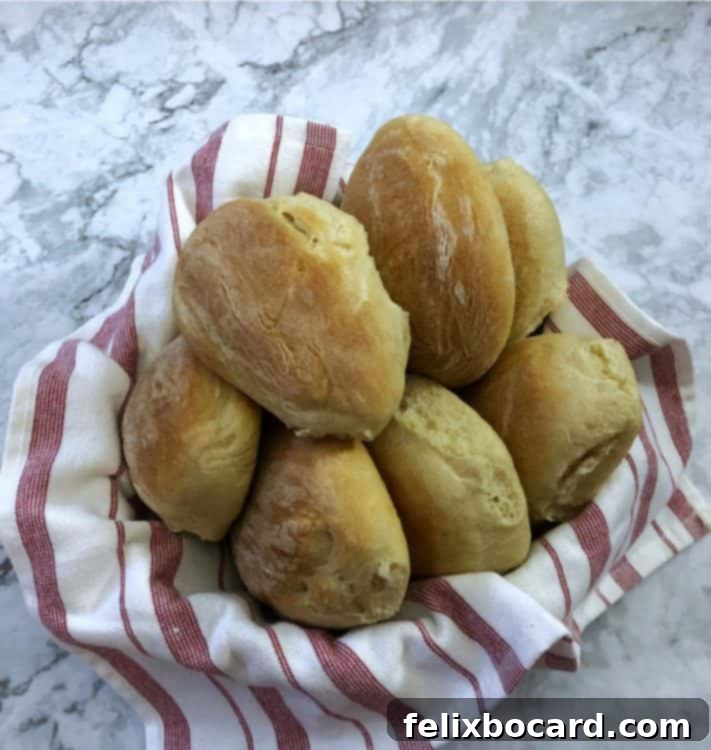 Deli Style Sandwich Rolls 6 A basket lined with a towel holding several homemade sub rolls