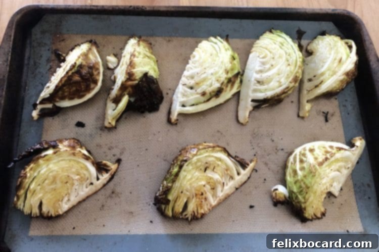 Perfectly roasted cabbage wedges, golden brown and tender, artfully arranged on a baking sheet, ready to serve.