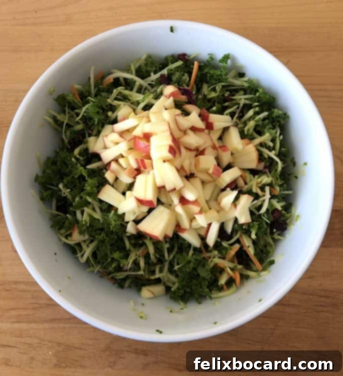 chopped apples added to the salad in a bowl