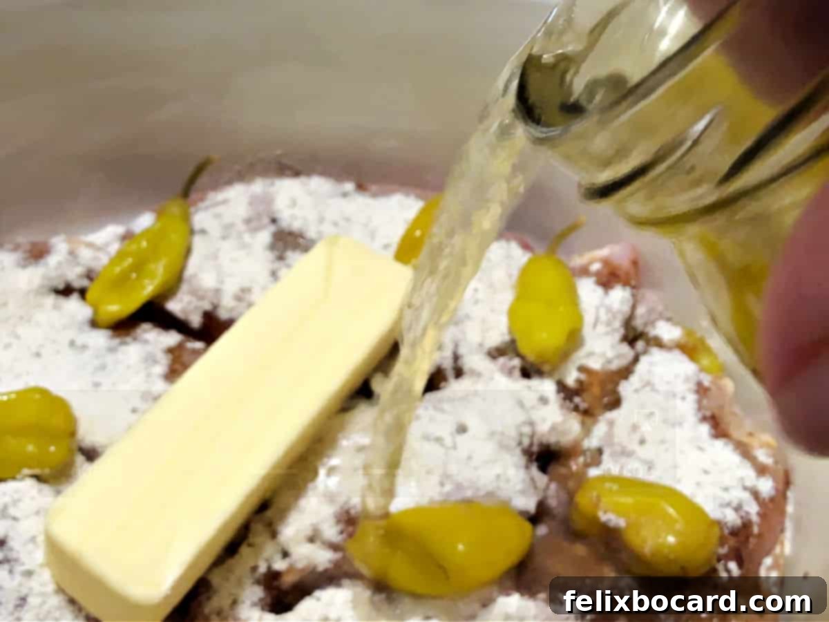 Adding pickle juice to the crockpot with butter and peppers.