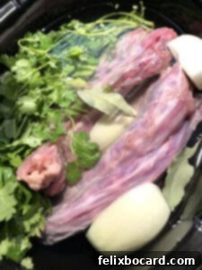 All ingredients for bone broth neatly arranged in a slow cooker, ready to begin the long simmering process.