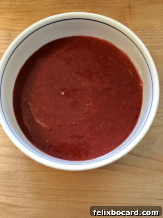 Jam-Filled Doughnut Bake 3 Rich, vibrant red strawberry cake filling in a bowl