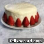 Jam-Filled Doughnut Bake 8 Layer cake frosted with white froating and decorated with fresh strawberries