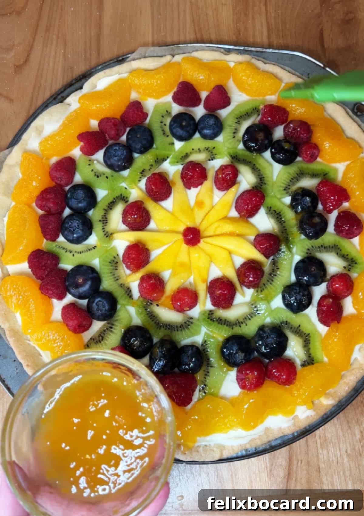 Brushing apricot preserves on top of the fruit.