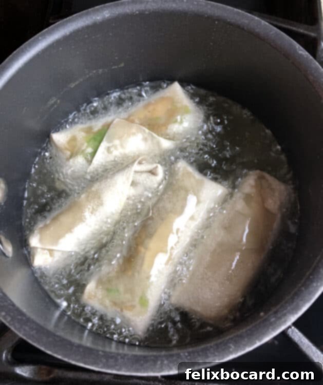 homemade egg rolls starting to cook in oil