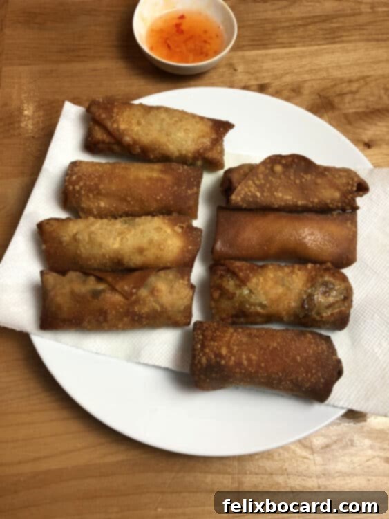 homemade egg rolls draining on paper towel lined plate