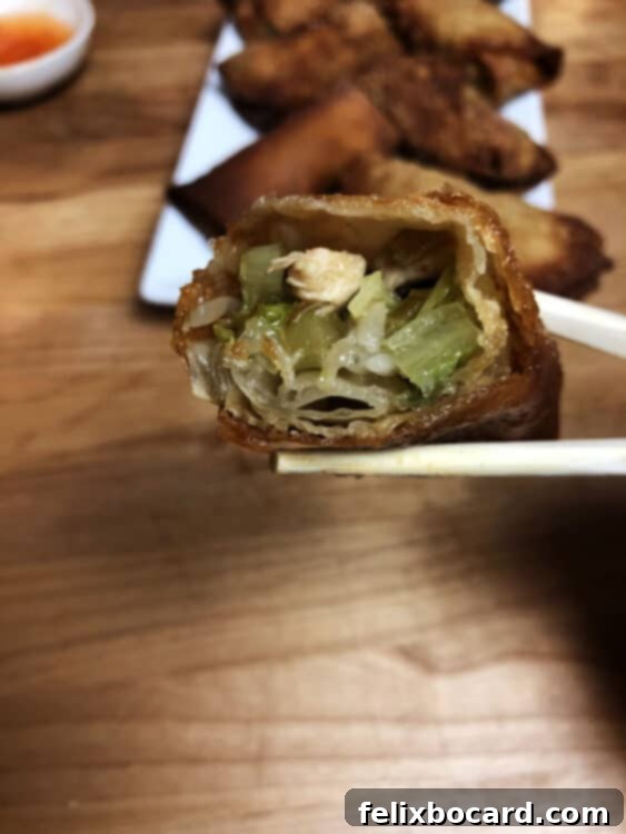 close up of homemade egg roll with a bite removed, showing the filling inside