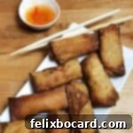 arrangement of homemade eggg rolls on a platter with dipping sauce