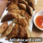 serving platter of potstickers with some dipping sauce