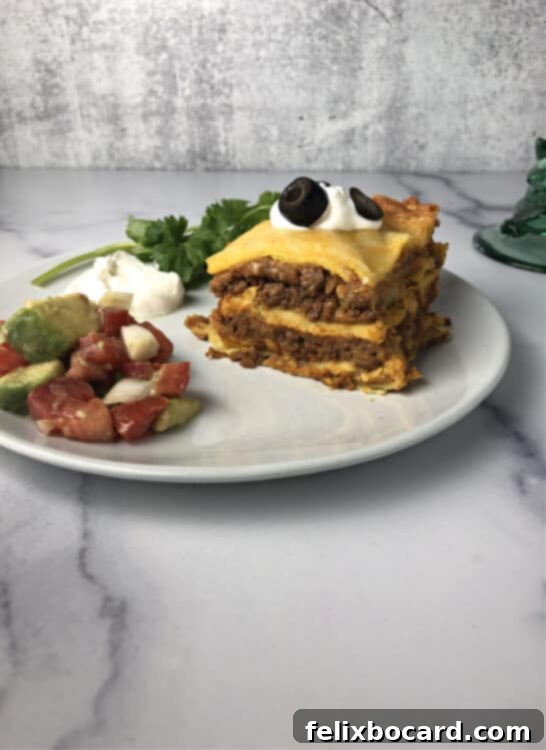 Burrito Bake 2 piece of burrito pie on a plate with salsa and sour cream