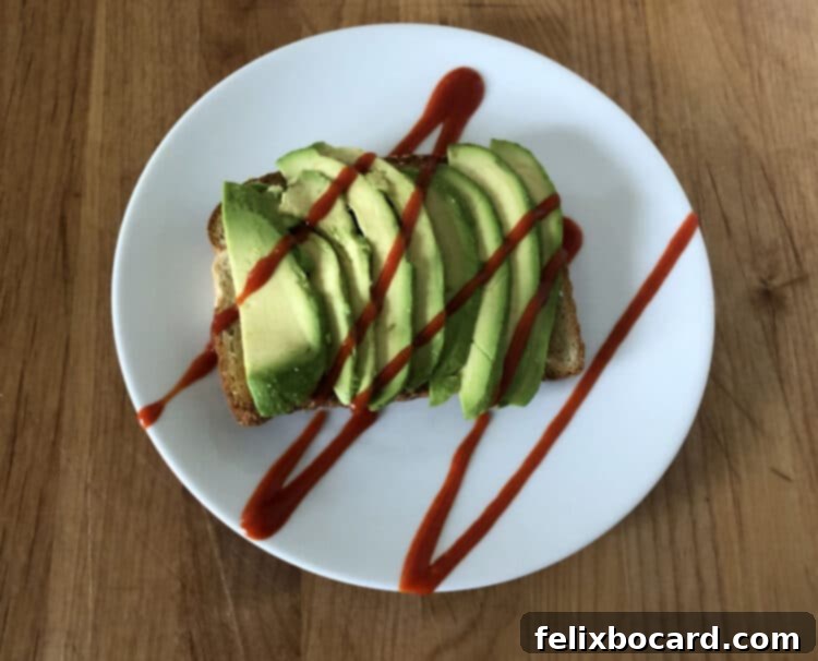 13 Creative Avocado Toast Recipes 12 Avocado toast featuring a generous drizzle of hot sauce, adding a fiery kick to the creamy avocado.