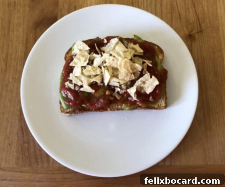 13 Creative Avocado Toast Recipes 13 Avocado toast topped with vibrant salsa and crunchy crushed tortilla chips, creating a delicious Tex-Mex inspired meal.