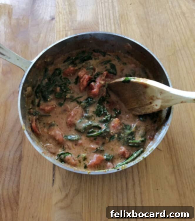 The finished creamy spinach and pesto pasta sauce, perfectly stirred and ready to coat your favorite pasta.